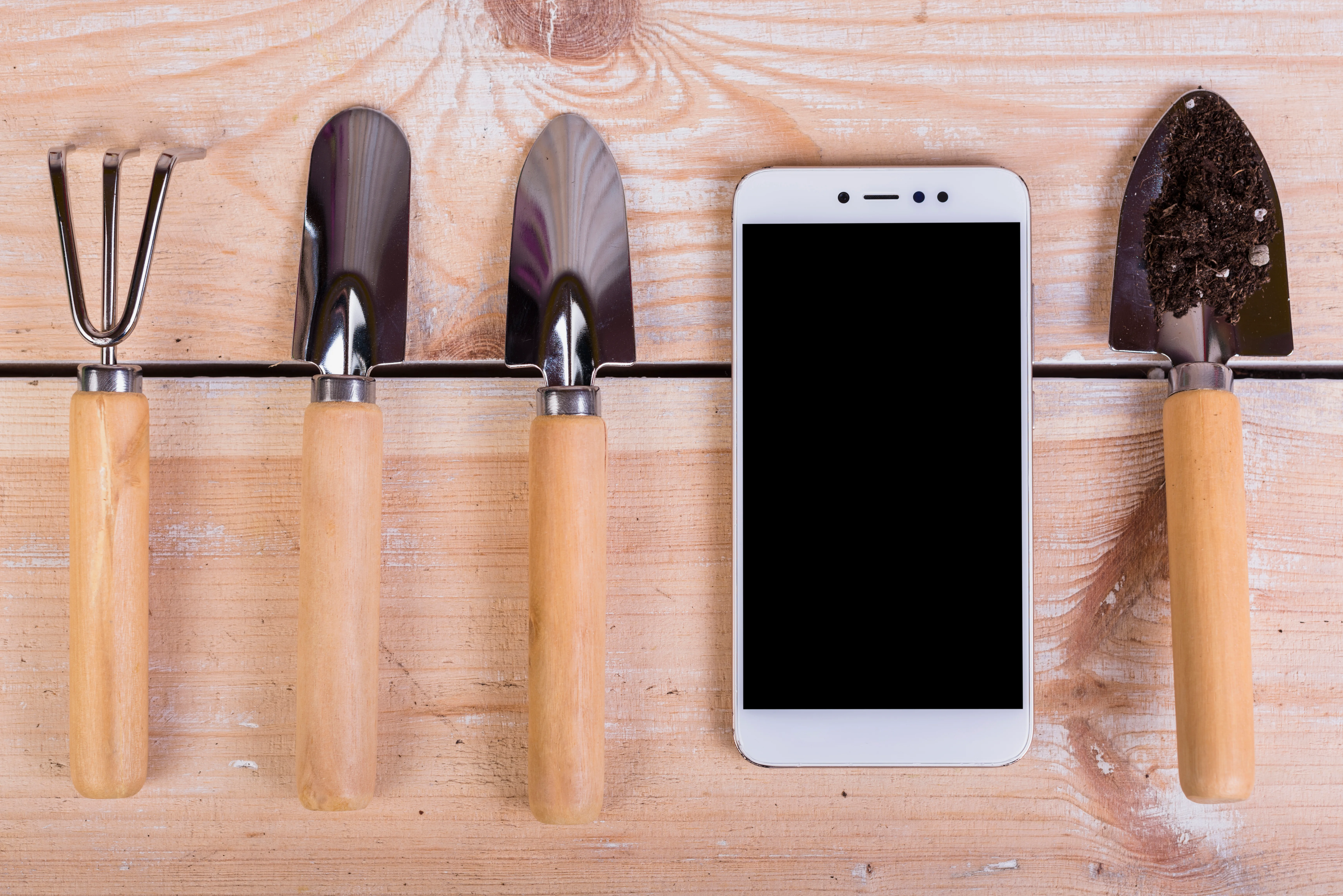 Landscaper with phone – managing jobs and calls while on site